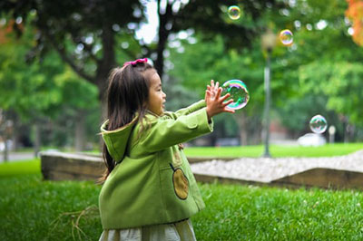 picture of young girl catching a bubble