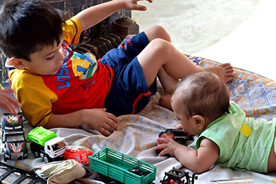 picture of toddler and baby playing on the floor