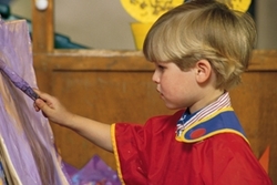 photo of young child painting