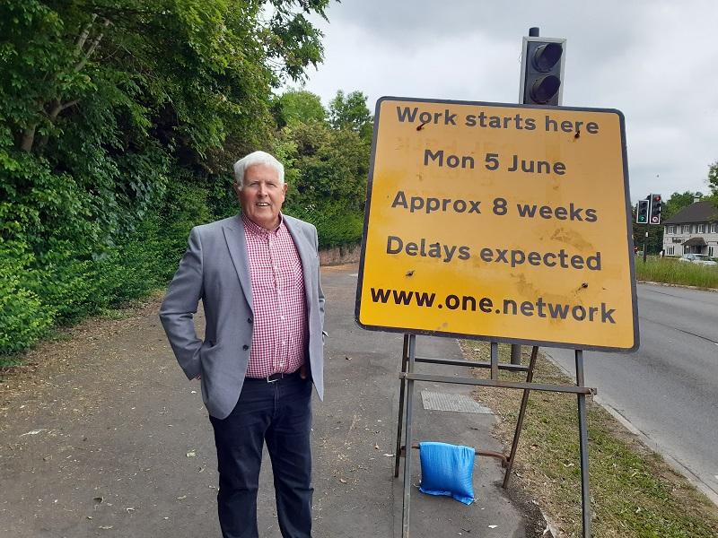 Cllr Ken Hawkins next to one of the signs for the works