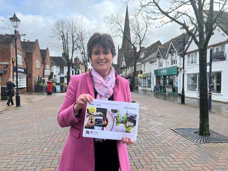 Cllr Karen Grinsell holding the Destination Management Plan in Solihull town centre