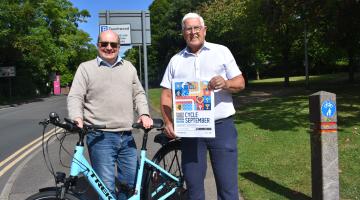 Cllr Andy Mackiewicz and Cllr Ken Hawkins stood next to a bike.