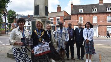 Leader of the Council, Councillor Karen Grinsell and the Mayor of Solihull, Annette Mackenzie standing with dignitaries next to a war memorial along the trail