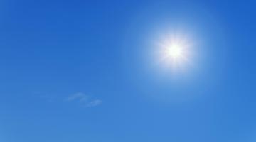 The sun shining, with a blue sky