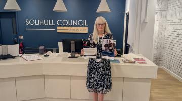 Councillor Delaney holding promotional materials for the employment support programmes
