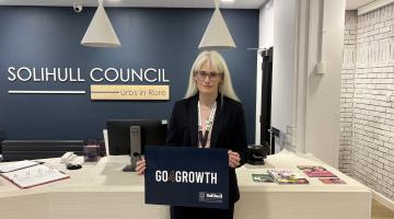 Councillor Heather Delaney stood with the logo of the Council's new partner Go4Growth