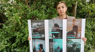 Cllr Wazma Qais, Cabinet member for domestic abuse, holding up posters from the "Solihull stands together against domestic abuse" campaign