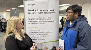 A young person learning about apprenticeship opportunities from an exhibitor.