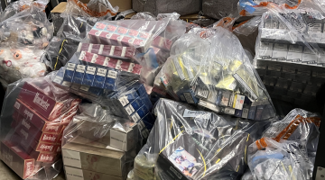 A dozen large bags of multiple cartons of illegal cigarettes and vapes