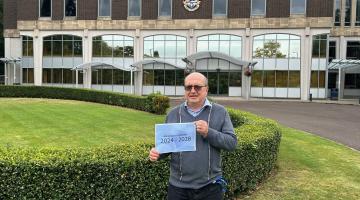 Cllr Mackewiecz, holding up a copy of the air quality strategy