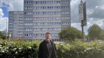 Dr Neil Roberts in front of high rise flats in Chelmsley Wood