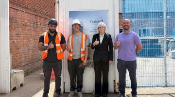 Matthew, Ryan, Cllr Delaney and Paul outside the construction site that Ryan's working at