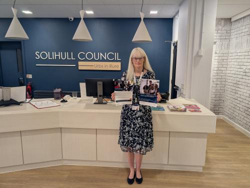 Councillor Delaney holding promotional materials for the employment support programmes