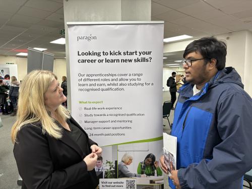 A young person learning about apprenticeship opportunities from an exhibitor.