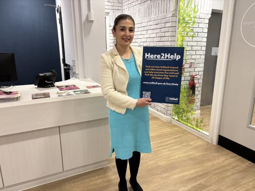 Councillor Qais posed with Here2Help poster