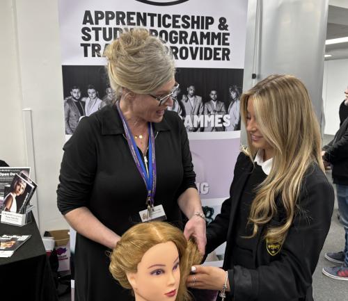 A student exploring training opportunities with an exhibitor at the last show.
