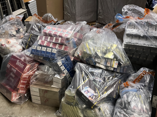 A dozen large bags of multiple cartons of illegal cigarettes and vapes