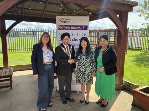 sally tomlinson, cllr marwa, anne hastings and mrs marwa in front of an age uk solihull pull up banner