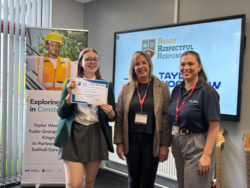 A student receiving a certificate from Rachel Galley, Social Value Manager and Maisie Haddock, Social Value Apprentice from Taylor Woodrow.