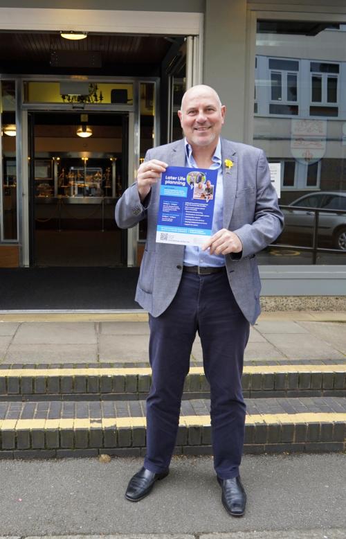 Cllr Tony Dicicco holding a poster to promote the events